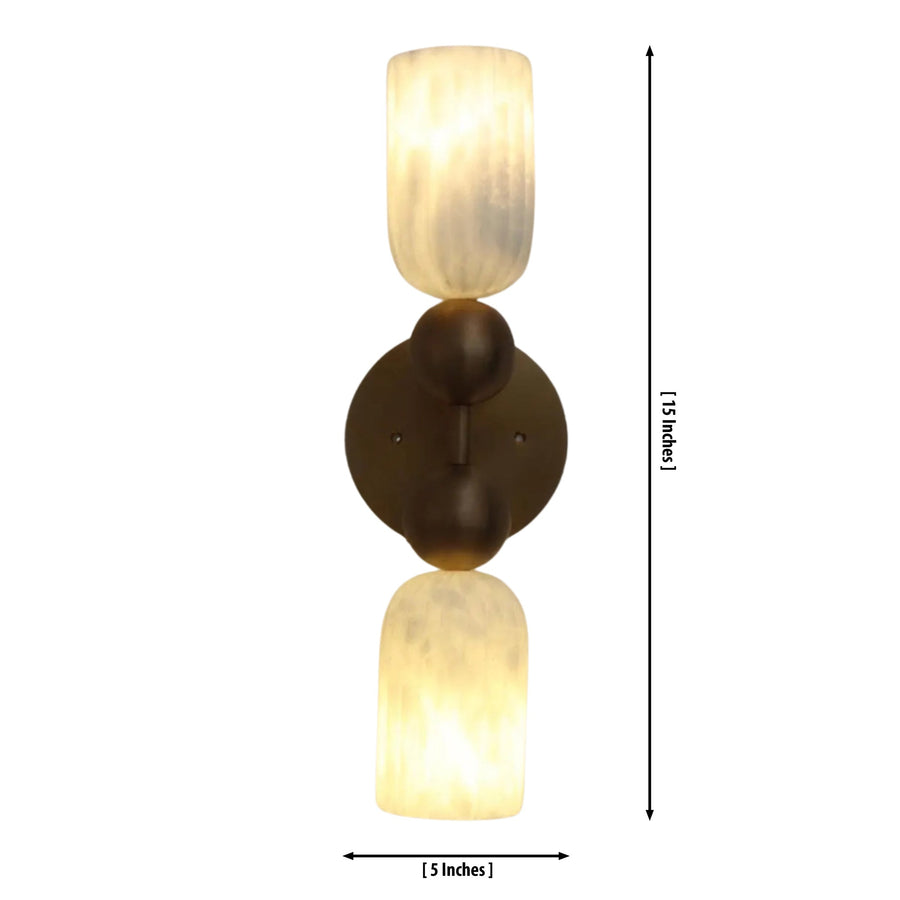 Sloane Dual Alabaster Globe Wall Sconce installed in a contemporary living room, casting warm ambient light above a wooden console with decorative accessories and modern furnishings.