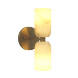 Sloane Dual Alabaster Wall Sconce with vertically stacked cylindrical alabaster shades illuminated on a brushed brass backplate, front view.