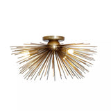 Soho 5 light antique brass tone sunburst flush mount chandelier featuring radiating metal rods and illuminated bulbs.
