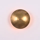 Front view of Solene Shield Wall Sconce with rounded shield disc and central decorative finial.