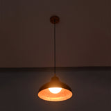 Detailed view of Sutton hammered copper pendant light with illuminated globe bulb and textured handcrafted dome shade.