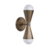 Illuminated Verona hourglass globe wall sconce in antique brass finish showcasing warm ambient up-and-down lighting with exposed globe bulbs.