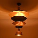 Illuminated close-up of the Verona Layered Disc Pendant Chandelier displaying the warm brass interior and softly diffused ambient lighting.