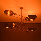 Verona Orbital chandelier shown illuminated from an angled view, highlighting layered bowl shades and warm glow.