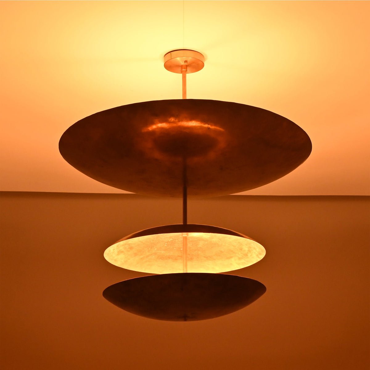 Close up of Verona Triple Saucer Chandelier highlighting the broad upper shade and warm layered glow.