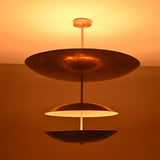 Verona Triple Saucer Chandelier glowing warmly with three layered saucer shades and soft ambient illumination.