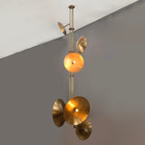 Sculptural brass chandelier with disc-shaped reflectors emitting warm indirect light in a modern space.