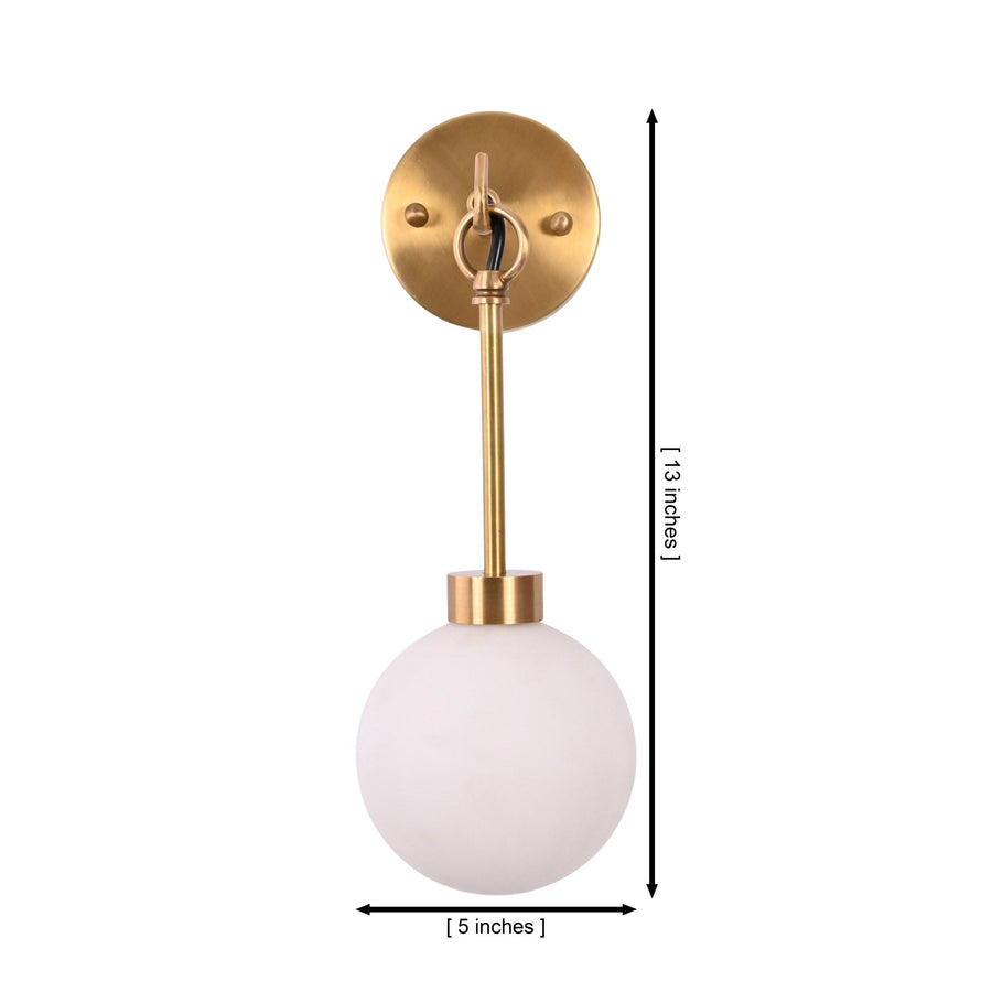 Windsor Modern Brass Globe Wall Sconce installed in a sophisticated home office, casting warm ambient light above a wooden desk with bookshelves, decorative accents, and a large window.