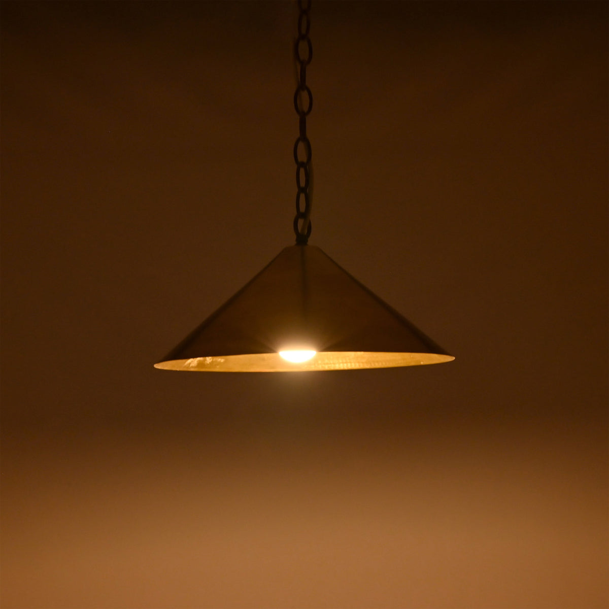 Adjustable chain cone pendant light with brass canopy and warm downward illumination for refined ceiling lighting