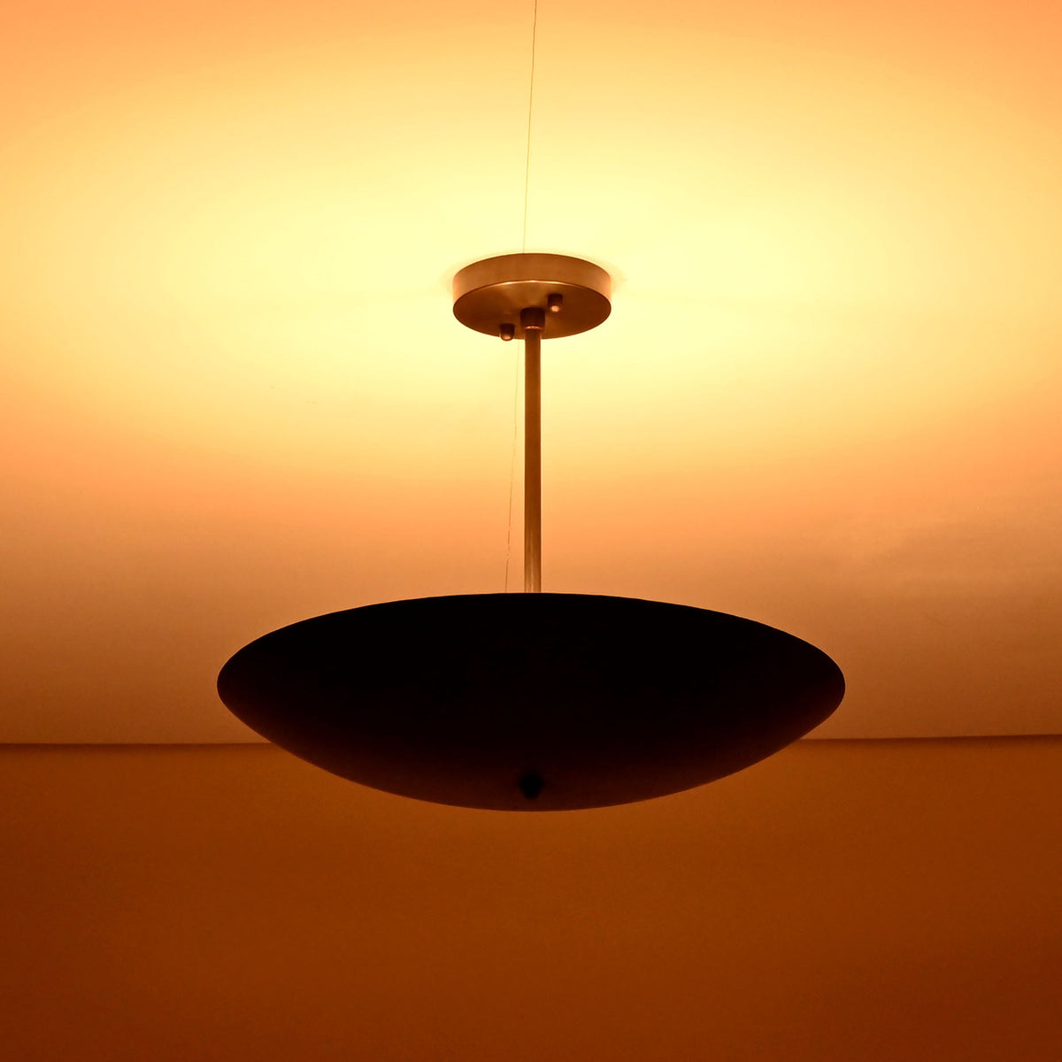 Ambient brass ceiling chandelier radiating soft warm light across the ceiling