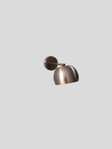 Angled view of handcrafted antique brass wall light with brushed patina finish and modern silhouette