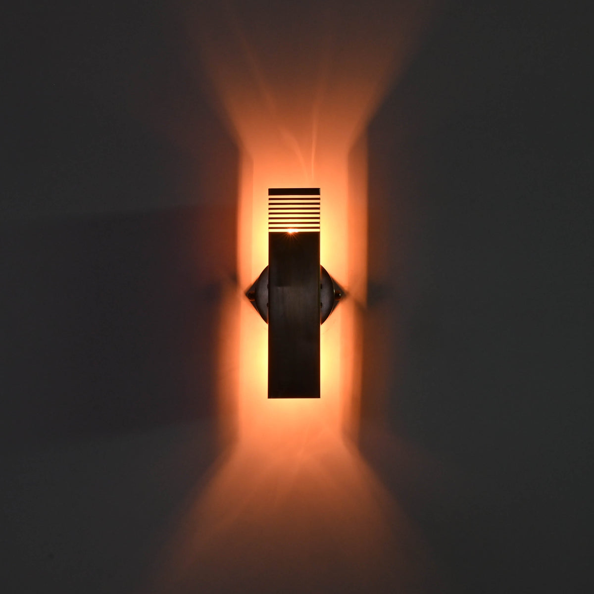 Architectural brass wall wash light with vertical rectangular shape and warm upward and downward glow for modern interiors
