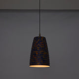 Artistic ribbed pendant light adding warm ambient glow to a stylish interior with wooden furniture and soft décor
