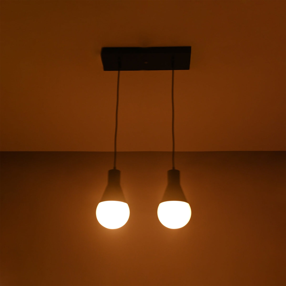 Aspen Dual Socket Pendant Chandelier Model 33242 illuminated against a dark background, showcasing warm ambient lighting.