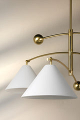 Close-up of white cone shaped shades on balance brass chandelier highlighting minimalist modern design