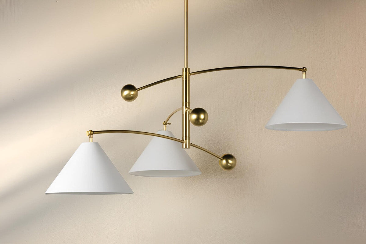 Balance brass chandelier installed in modern interior showing warm ambient lighting and sculptural brass arms
