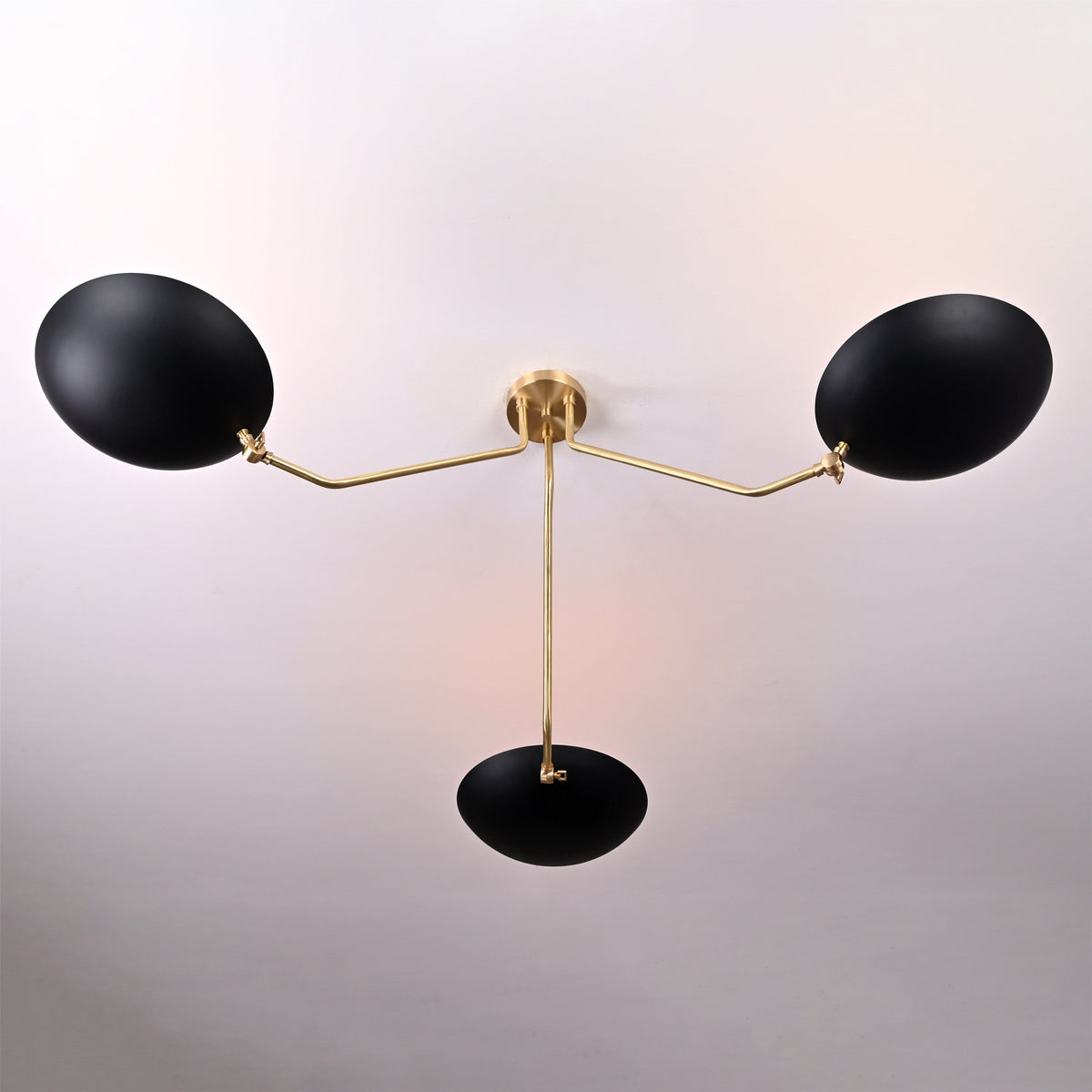 Top view of black and brass bowl chandelier showing elegant curvature of the brass arms and central support.