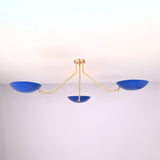 Modern three-light flush mount ceiling light with blue bowl shades and brushed brass arms by Brass Leaf Studio
