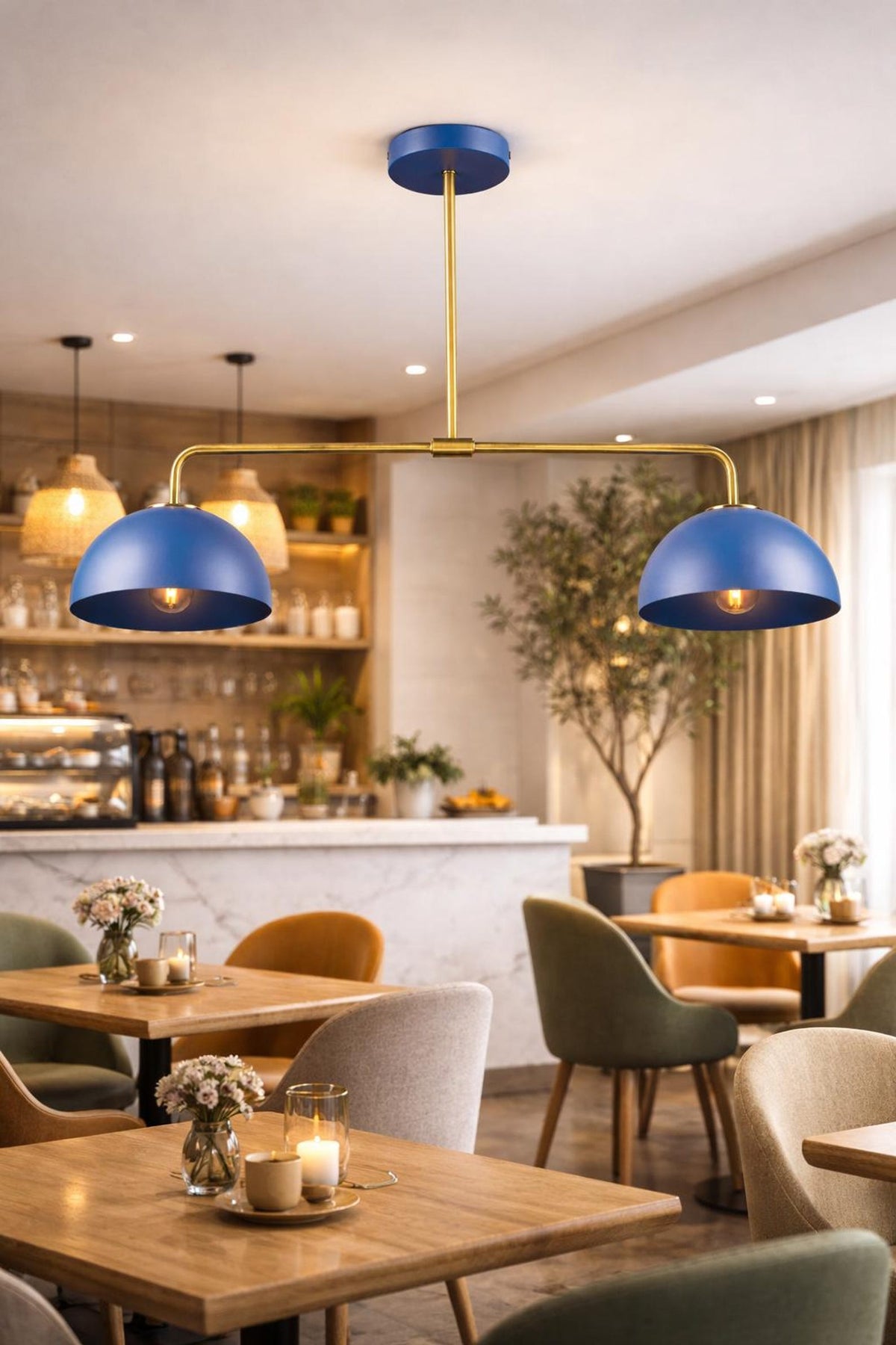 Blue double dome brass chandelier hanging above café tables with modern interior décor and warm lighting.