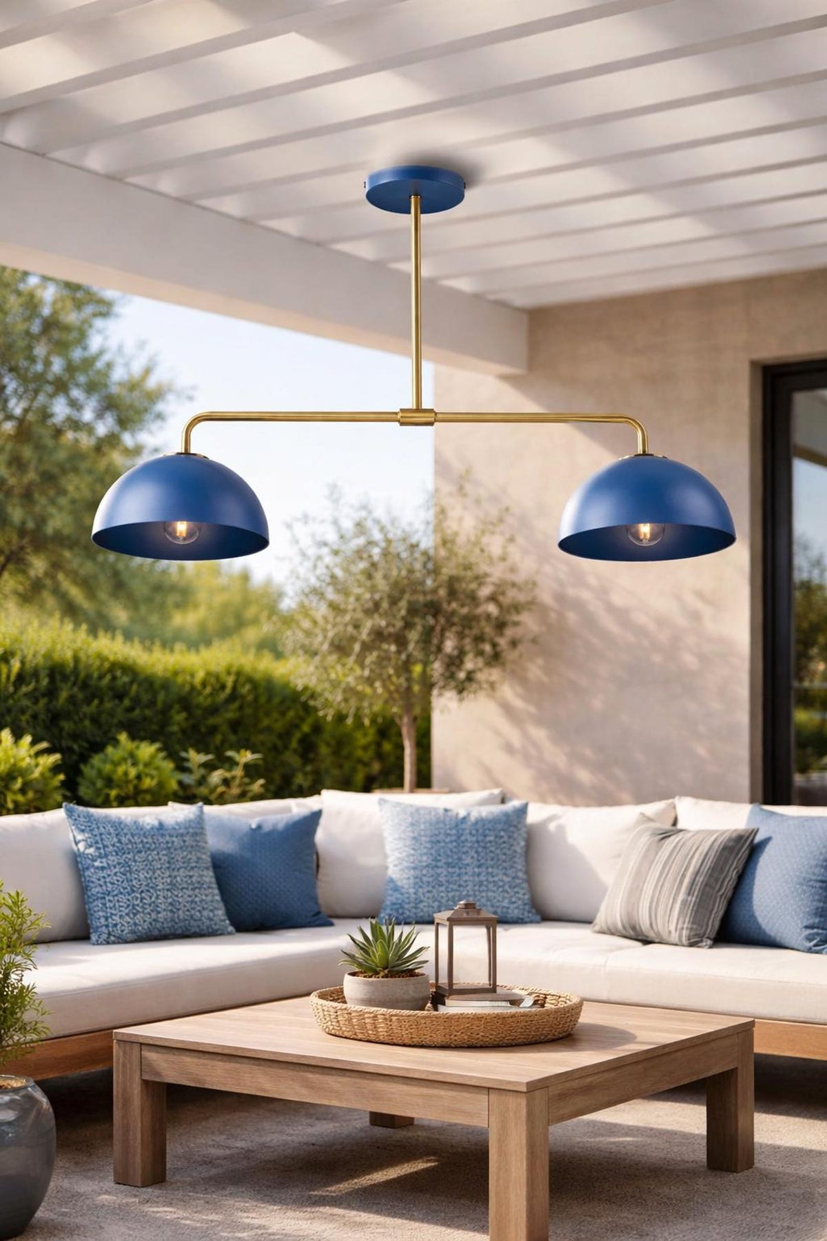 Blue dome brass chandelier installed in outdoor patio setting with sectional seating and wooden pergola ceiling.