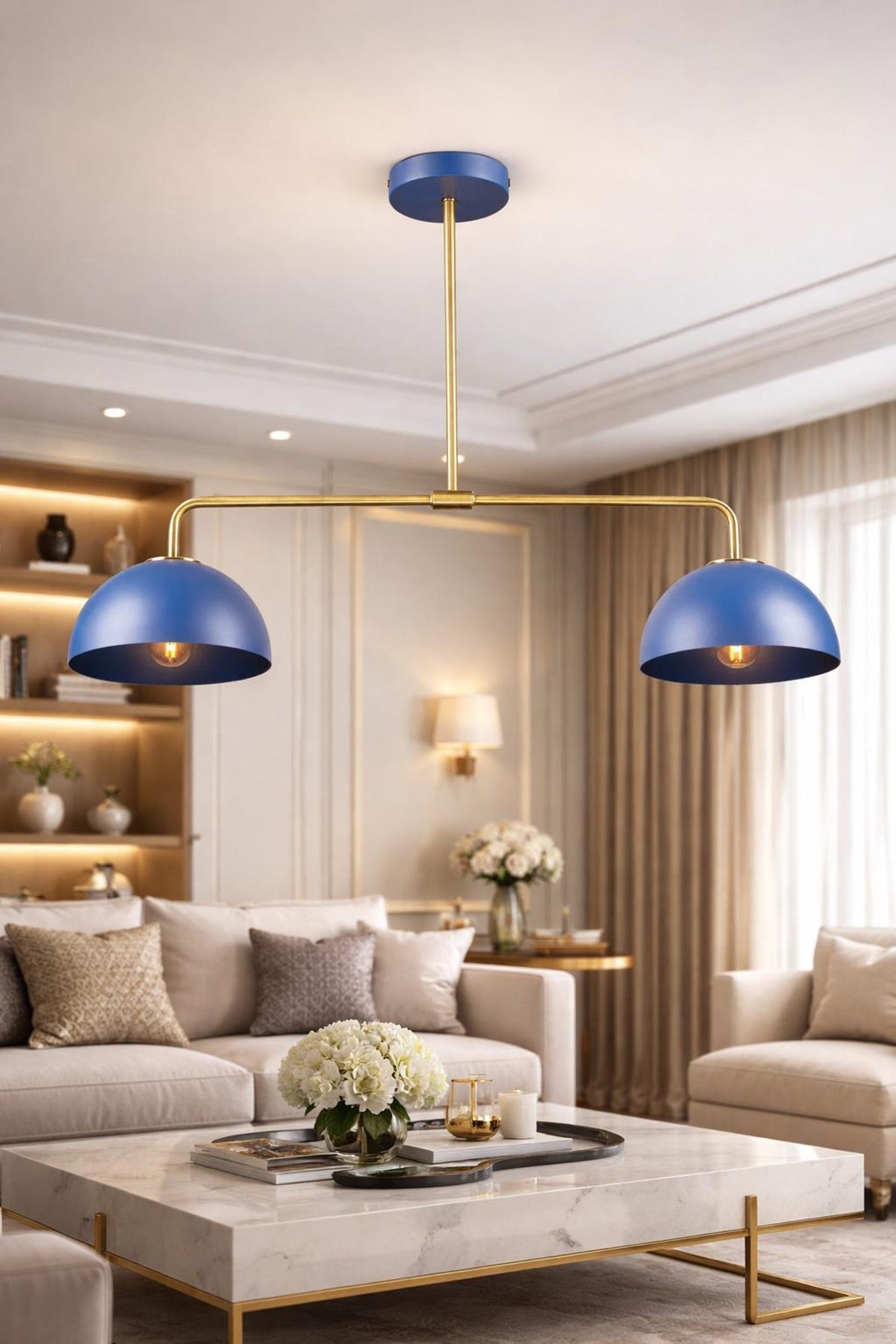 Modern blue dome brass chandelier centered in luxury living room with neutral sofa and marble coffee table.