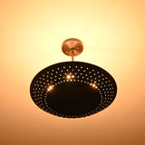 Bottom view of illuminated brass disc chandelier radiating indirect warm light