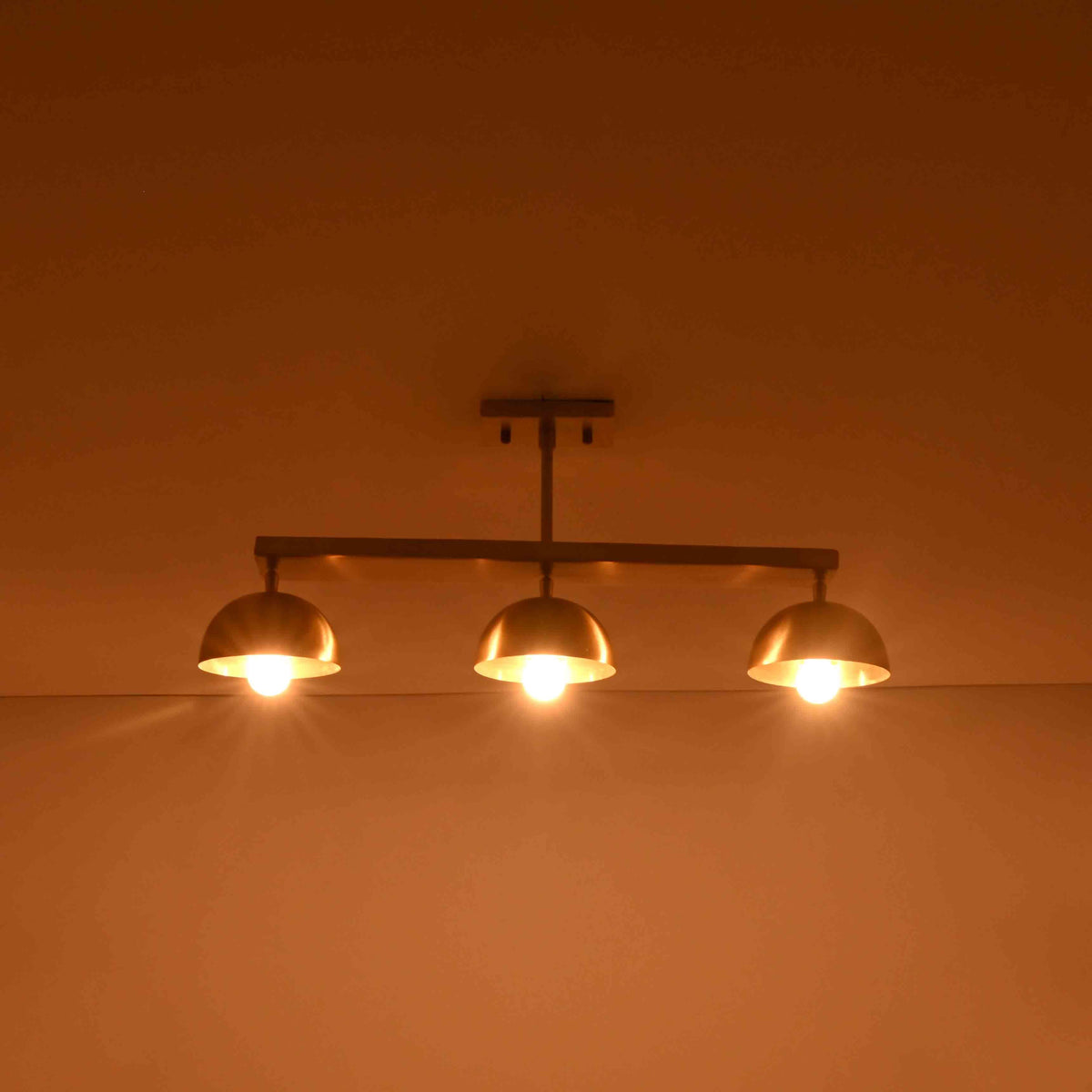 Three light ceiling fixture shown illuminated, creating warm downward glow for bedrooms, dining rooms, and living spaces