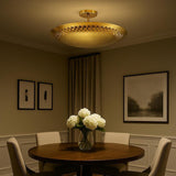 3 light brass disc style flush mount chandelier installed above a dining table