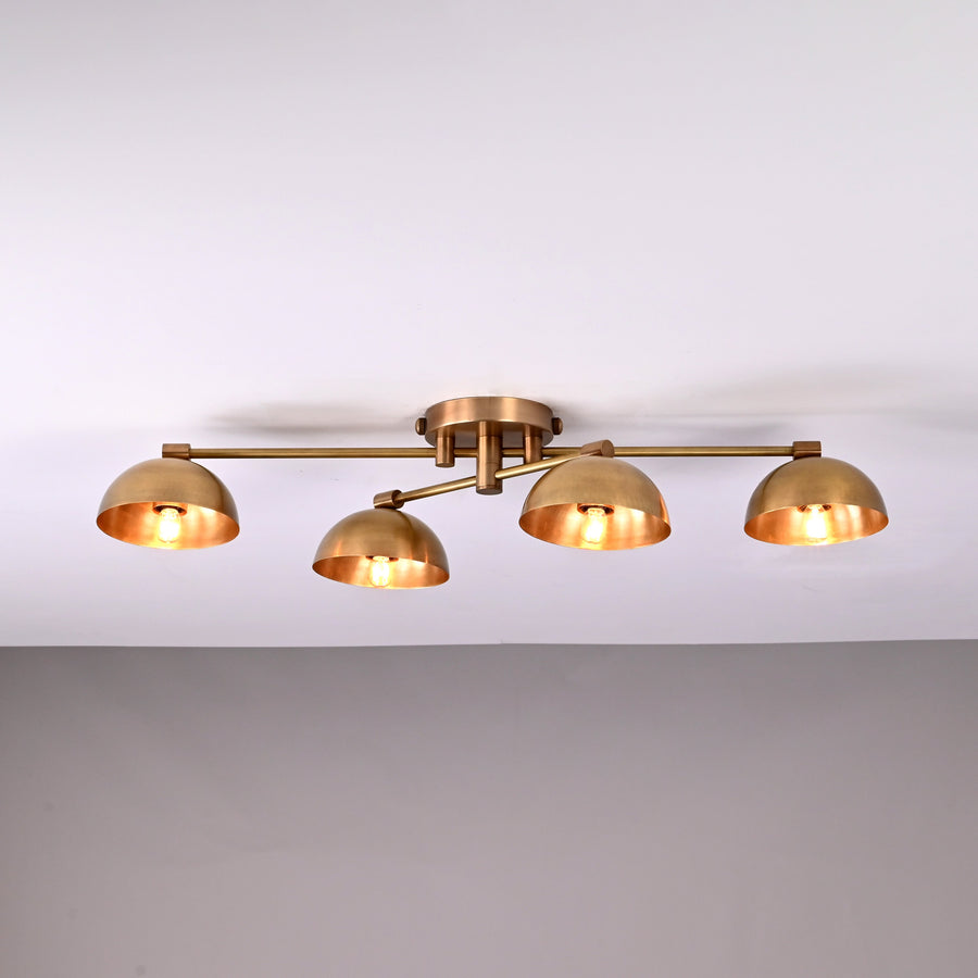 Handmade brass ceiling light with four dome-shaped shades illuminated, modern low-profile 4-light fixture for living room or hallway.