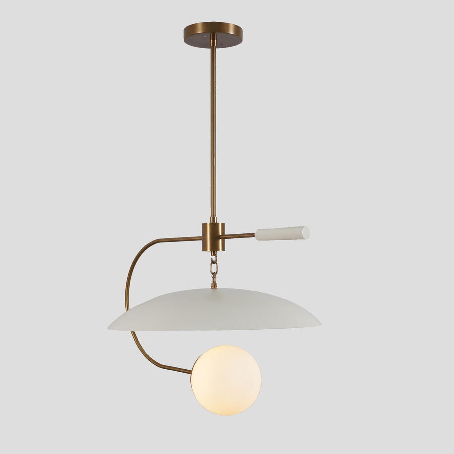 Modern brass pendant light featuring a white dome shade and frosted globe design, creating a balanced minimalist statement for contemporary interiors.
