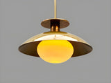 Handmade brushed brass bowl ceiling light glowing warmly with glass globe, modern minimalist brass lighting design