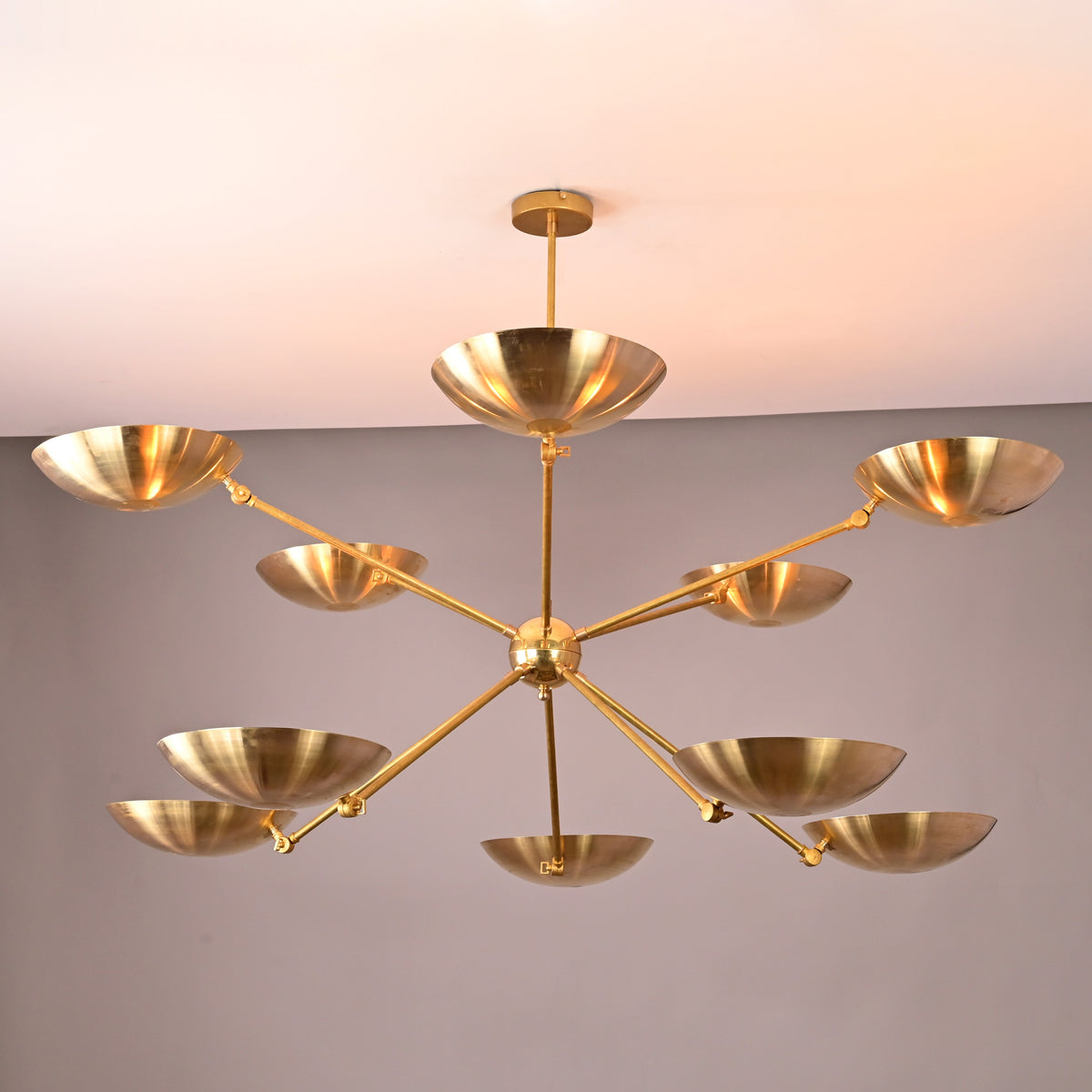 Wide 59-inch brass bowl chandelier showcasing ten sculptural uplight bowls on extended brass arms.