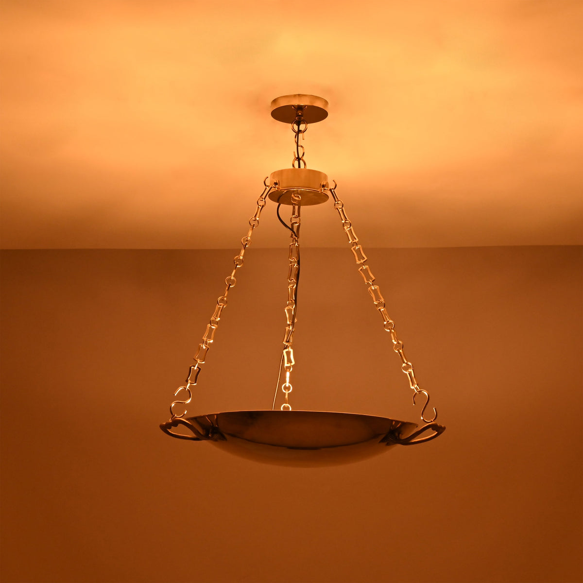 Brass bowl chandelier in an elegant living room creating warm ambient ceiling light and a refined classic interior look