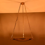 Chain-suspended brass bowl chandelier illuminated at night with warm ambient glow