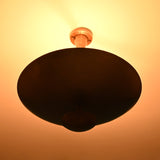 Brass bowl disc chandelier in low-light setting highlighting warm ceiling glow, sculptural form, and elegant minimalist presence