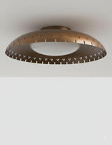 Bottom view of brass bowl flush mount ceiling light featuring disc glass globe and precision perforated detailing