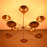 Warm-lit view of the 10-light brass bowl chandelier casting soft ambient ceiling illumination.