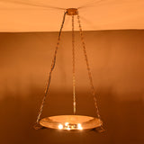 Night view of brass bowl chandelier showing soft uplighting and chain-supported design