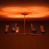 Perforated brass cone shades producing soft glowing light in a modern handcrafted chandelier by Brass Leaf Studio.