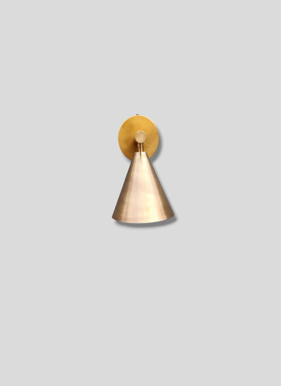 Side view of modern brass cone wall light handcrafted by Brass Leaf Studio in brushed raw brass finish, mounted on neutral background.
