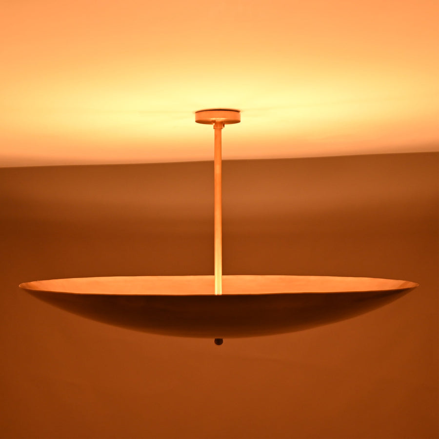 Handmade brass bowl pendant light with a smooth disc shape, modern solid brass ceiling fixture.