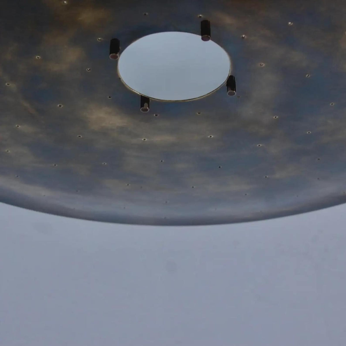 Close-up detail of brass disc ceiling light showing central opening, precision hardware, and hand-finished brass surface.