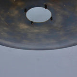 Close-up detail of brass disc ceiling light showing central opening, precision hardware, and hand-finished brass surface.