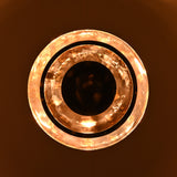 Glowing night view of multi-tier brass disc chandelier with warm indirect lighting