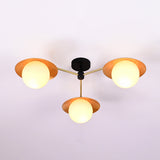 Angled view of handcrafted brass flush mount ceiling light featuring disc shades and opal glass globes.