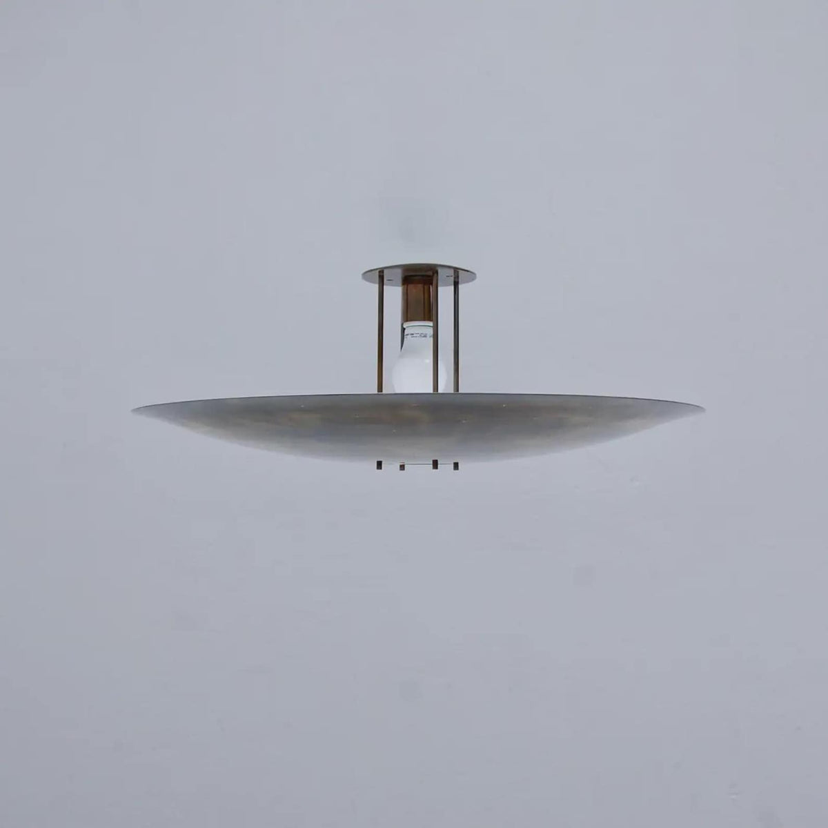 Side profile of modern brass disc flush mount ceiling light highlighting slim proportions and solid brass construction.