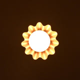 Brass disc pendant light casting warm ambient glow in a dark interior setting.