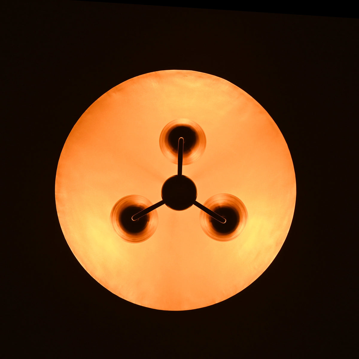 Warm illuminated bottom view of brass dome shade chandelier, highlighting soft ambient glow and sculpted brass fixtures.