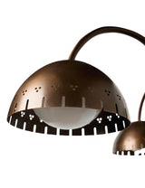 Close-up of perforated brass dome shade showcasing handcrafted detailing and warm light diffusion