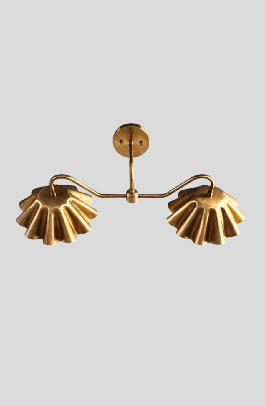 Custom brass wall sconce with two ruffled shades – side angle